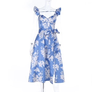 Detail of blue floral dress featuring a ruffled neckline and a large waist bow tie
