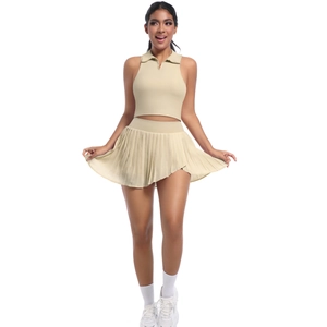 Détail d'un haut sans manches beige avec col polo et jupe plissée assortie à taille haute