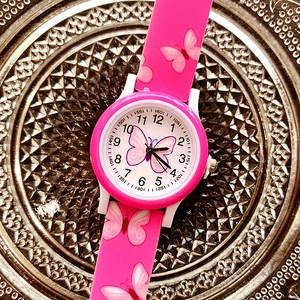Close-up of pink butterfly print silicone strap and dial on a cute kids quartz watch