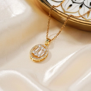 Elegant gold necklace with oval zircon pendant displayed on light silk background