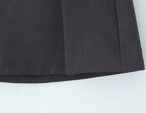 Detailopname van nauwkeurige stiksels en fijne stof op de zoom van een grijze mini-rok