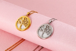 Detailed close-up of tree of life pendants in gold and silver with mother of pearl inlay