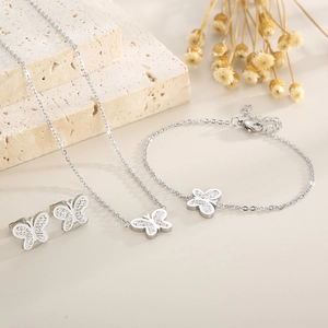 Macro view of silver butterfly jewelry set with sparkling crystals on a stone base