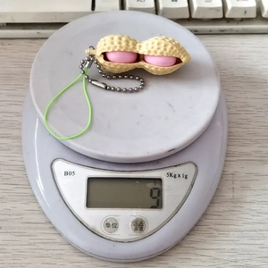 Vue détaillée d'un jouet anti-stress arachide sur une balance pesant 9 grammes