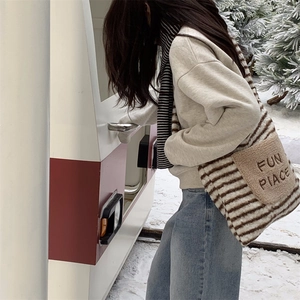 Close-up of fuzzy tote bag with 'FUN PLACE' embroidery against a snowy winter background