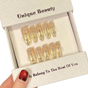 Golden cat-eye press-on nails set with sparkling heart rhinestones and chain details