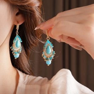 Détails de boucles d'oreilles bohèmes vintage avec perles turquoise et pompons dorés