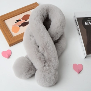 Detail of grey plush faux rabbit fur scarf with decorative pom-poms on white background