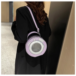 Detail view of a unique purple washing machine shaped shoulder bag worn by a model