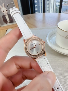 Octagonal diamond-set rose gold watch with white crocodile pattern leather strap in hand
