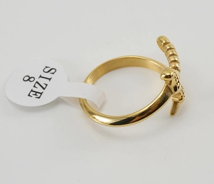 Detailed macro view of gold-plated sword-shaped ring featuring size 8 label and metal finish