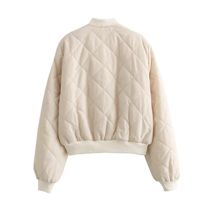 Vue détaillée du motif matelassé en losange et de l'ourlet côtelé d'un blouson crème