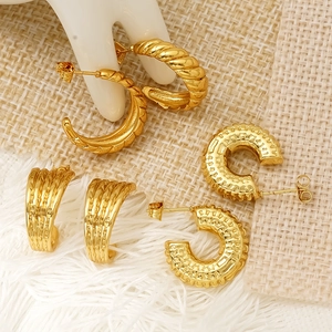 Three pairs of vintage gold stainless steel hoop earrings with textured patterns