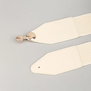 Detail of beige elastic waist belt featuring premium golden round metal buckle and PU leather