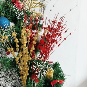 Glittery Christmas berry stems in red, gold, and silver with festive bow on wreath