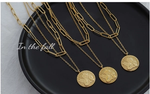 Detail of 18K gold-plated double-layer necklace with angel relief coin pendant