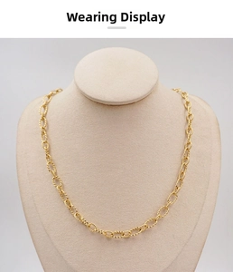 Detail of golden twist chain necklace with oval rope textured links on display