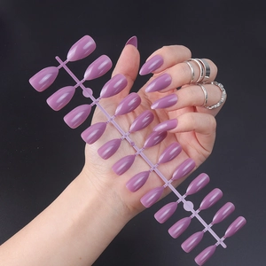 Glossy lilac stiletto press-on nails set shown on model against black background
