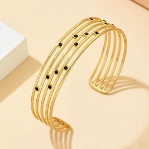 Bracelet manchette ajustable multicouche en acier doré avec détails de perles noires