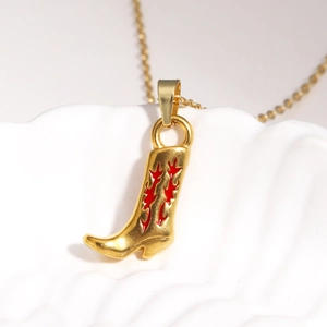 Détails macro d'un pendentif botte de cow-boy dorée avec motifs de flammes rouges vifs