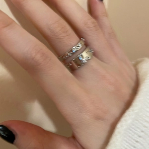 Detailed view of silver pleated rings with zircon accents on finger for daily fashion