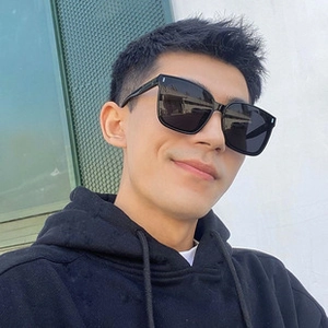 Close-up of black oversized square frame sunglasses with silver stud accents on male model