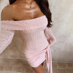 Détail de la mini-robe rose à épaules dénudées avec tissu texturé et lien à la taille