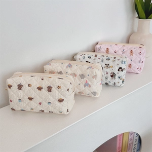 Detailed view of four quilted cotton pouches featuring cute animal and character patterns