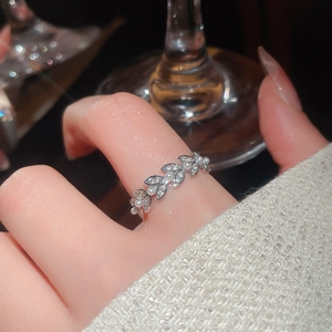 Close-up of zircon leaf ring with white pearls on finger in elegant setting