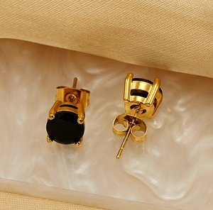 Macro detail of round black zircon stud earrings with 18k gold plated four-prong setting
