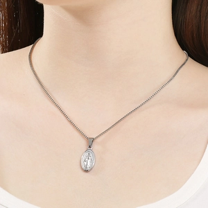 Close-up of silver oval religious pendant with Virgin Mary relief on box chain