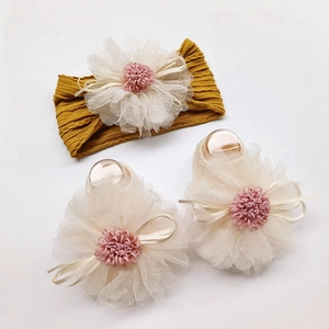 Close-up of ginger yellow baby headband and matching socks with mesh flower and bow detail