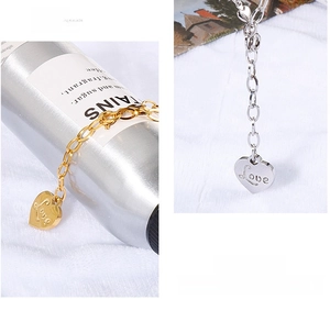 Detail view of heart-shaped Love pendant necklaces in gold and silver steel finishes
