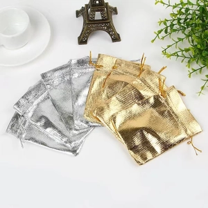 Flat lay of gold and silver drawstring jewelry pouches with decorative props