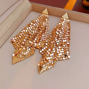 Detail of long gold mesh tassel earrings with geometric triangular metal accents