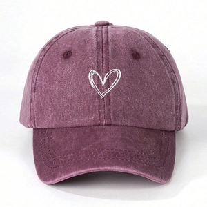 Detailed view of white heart embroidery on washed vintage purple cotton baseball cap