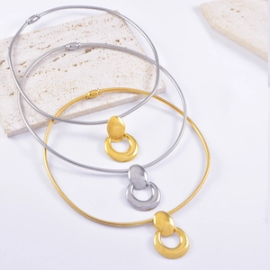 Close-up of sleek gold and silver polished U-shape collars on a modern stone tray