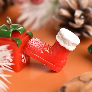 Macro shot of resin Christmas gift box and Santa boots miniature with festive pine background