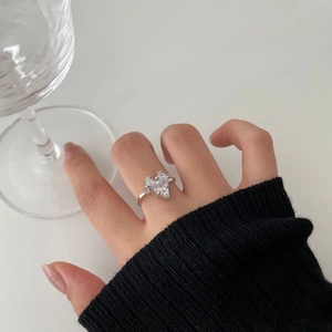 Macro detail of minimalist silver ring featuring a large triangular cut zircon stone