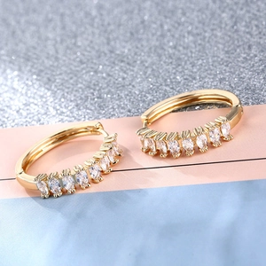 Minimalist gold plated hoop earrings with marquise-cut zircons on a colorful background