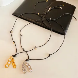 Collier avec pendentif cacahuète élégant et perles blanches sur cordon noir tressé
