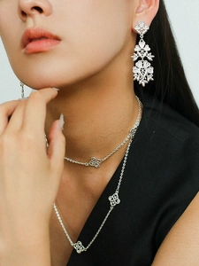 Detail shot of vintage silver hollow flower earrings and matching necklace set on model