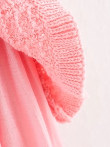 Detail of pink knitted fabric texture and smooth lining of the three-piece dress set