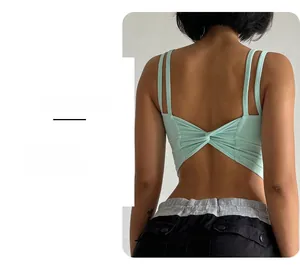 Close-up of mint green sports bra featuring an open back with cross-knot twist detail