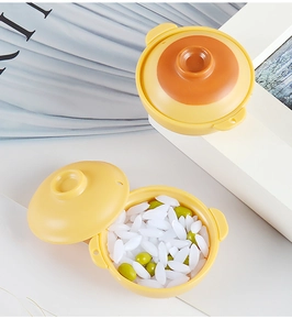 Close-up of a miniature yellow dollhouse clay pot with simulated rice and green peas