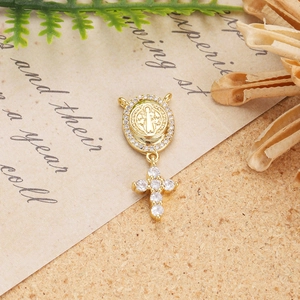 Macro detail of 18K gold religious medal with sparkling zircons on vintage background