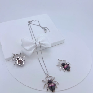 Detailed view of spider pendant set with black and pink zircons on display stand