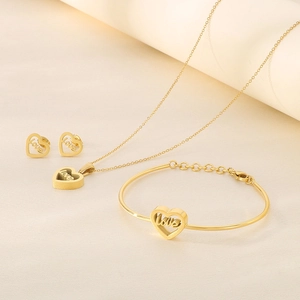 Detailed view of gold jewelry set with hollow heart pendants and 'love' engraving