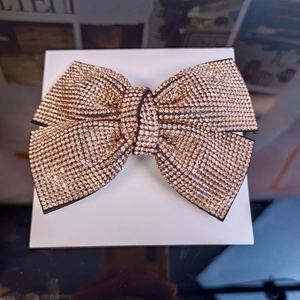 Close-up of sparkling rose gold rhinestone bow hair clip showing detailed pavé crystal setting