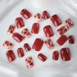Short square press-on nails with deep red autumn maple leaf patterns and gold glitter